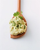 A spoonful of mashed potato with herbs