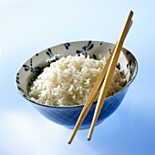 Reis in Schale mit Stäbchen