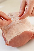 Tying rolled pork joint with kitchen string