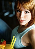 Freckled young woman with fruit cocktail