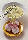 Bowl of aioli (garlic mayonnaise) & three garlic bulbs