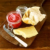 Piece of cheese, bread & marinated onions on wooden board