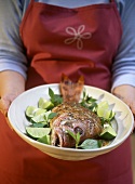 Woman holding platter of barbecued red snapper