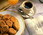 Teller mit spanischen Plätzchen, Zeitung, Tasse Kaffee