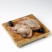 Two fresh quails on a wooden board