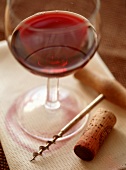 Red wine glass with corkscrew and cork