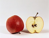 Ein ganzer und ein halber Apfel der Sorte Pinova