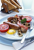 English breakfast: fried egg, bacon, sausage, tomato, mushrooms