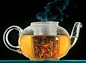 Steaming herb tea in glass teapot