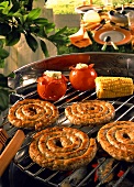 Barbecue scene with sausages and vegetables on the barbecue