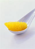 Wedge of orange on white spoon