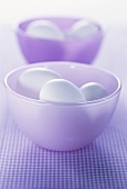 Two purple bowls with white eggs