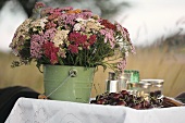Tisch im Freien mit Blumen und Kirschen