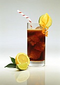 Glas Cola mit Eiswürfeln, Strohhalm, Zitrone, Limette