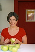 Frau schält einen grünen Apfel