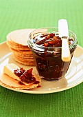 Tamarind and pineapple chutney in glass and on cheese crackers