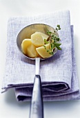 Cooked potatoes with herbs in ladle