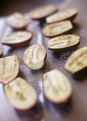 Salted aubergine halves on baking tray