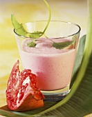 Pear yoghurt drink with pomegranate in glass