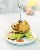 Muffin with burning birthday candle