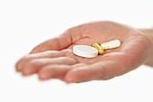 Vitamin tablets and capsules in a woman’s hand