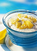 Quark dessert with pineapple and coconut flakes