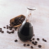 Coffee syrup in carafe; coffee beans