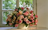 Bouquet of pink roses in front of window