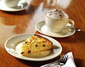 A piece of apple cake and a cup of cappuccino