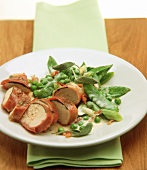 Chicken breast wrapped in Parma ham with peas in cream