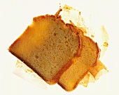 Two slices of lemon sponge cake on strips of baking paper