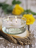 Three floating candles on a wooden platter