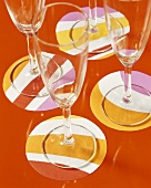 Four champagne glasses on coloured coasters