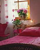 Comfortable bedroom with potted gerbera and hydrangea