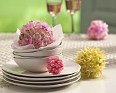 Balls of flowers and crockery on table