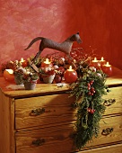 Advent decoration: round candles, mini-rocking horse & juniper