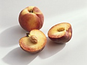 Peaches, variety ‘Royal Gold’, whole and halved