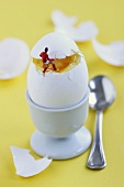 Miniature footballer taking the lid off a boiled egg