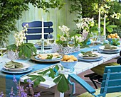 Gedeckter Tisch mit Spargel und Kastanienblüten dekoriert