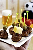 Skewered meatballs on a paper plate
