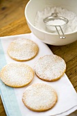 Four round biscuits dusted with icing sugar