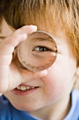 Boy looking through a biscuit cutter