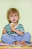 Small boy eating vanilla ice cream