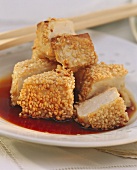 Deep-fried tofu cubes with sesame seeds in soy sauce