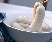 Several Weisswurst (Bavarian sausages) in dish of water
