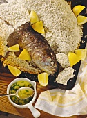 Salmon trout in sea salt crust with pieces of lemon