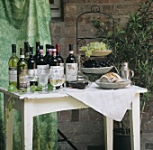 Various wine bottles, grapes on tiered stand & bread
