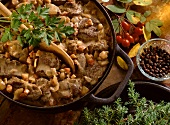 Wild boar ragout in cast iron pot with wooden spoon