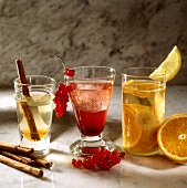 Cider drinks with cinnamon sticks, redcurrants, oranges
