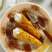 Brandy snaps filled with whipped cream, with cocoa powder